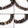 Gros plans des perles d'un bracelet en opale Boulder naturelle 8 mm révélant leurs magnifiques reflets et leurs motifs uniques.
