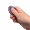 Main utilisant un worry stone en améthyste en frottant la pierre avec le pouce