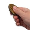 Main utilisant un worry stone en œil de tigre en frottant la pierre avec le pouce