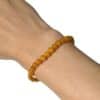 Bracelet en ambre naturel 4 mm porté au poignet, un bijou élégant réalisé avec des perles de qualité AA, appréciées pour leur rareté, leur éclat naturel et leur finesse.