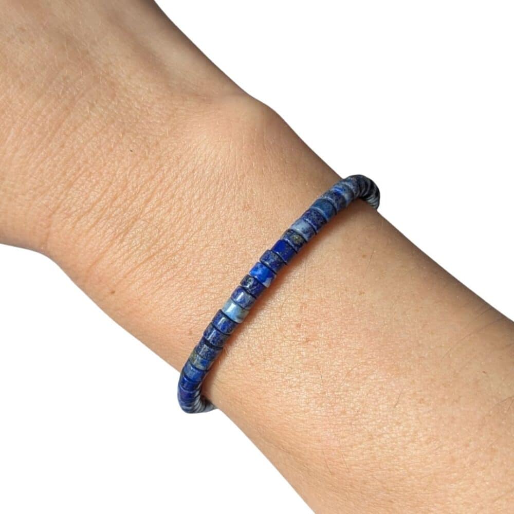 Bracelet Heishi en lapis-lazuli porté au poignet, un bijou élégant en pierre naturelle pour améliorer la communication et favoriser la sagesse intérieure.