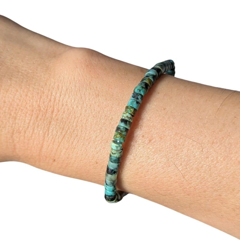 Gros plan d'un bracelet Heishi en turquoise d'Afrique naturelle aux magnifiques nuances vertes, favorisant l'équilibre, la confiance et l'ouverture d'esprit.